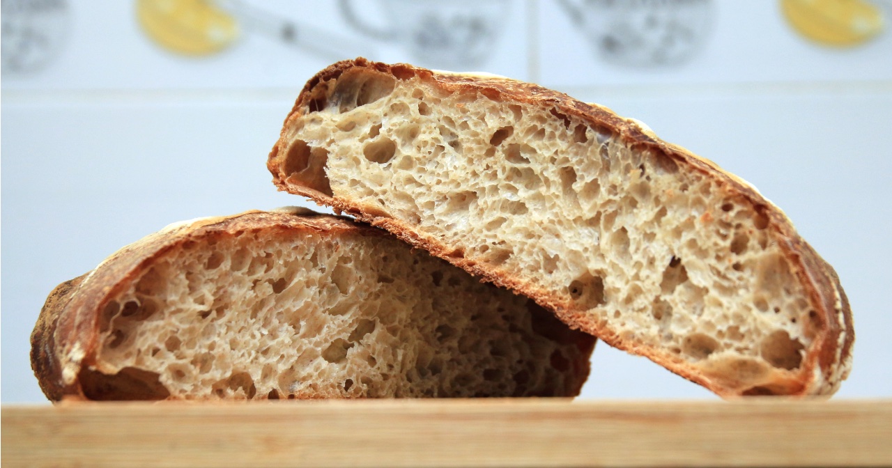 Loaf of bread cut in half on cutting board