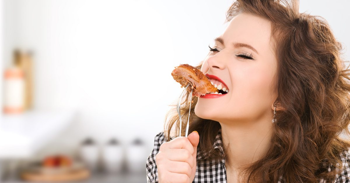 Woman eating a piece of steak