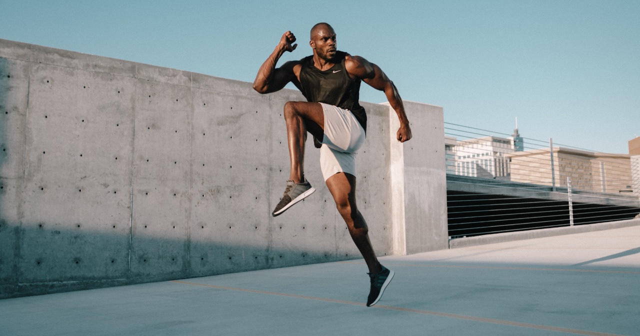 Male athlete bounding, doing hops outside in front of cement wall