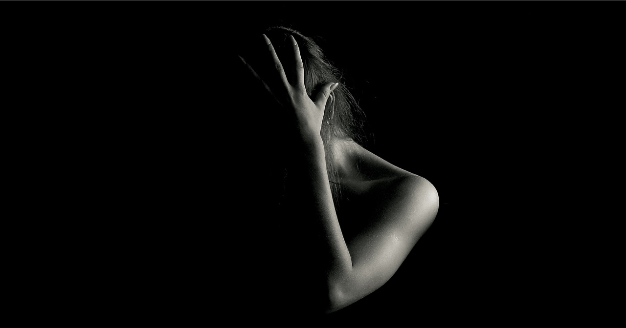 Woman holding her head in black and white photo