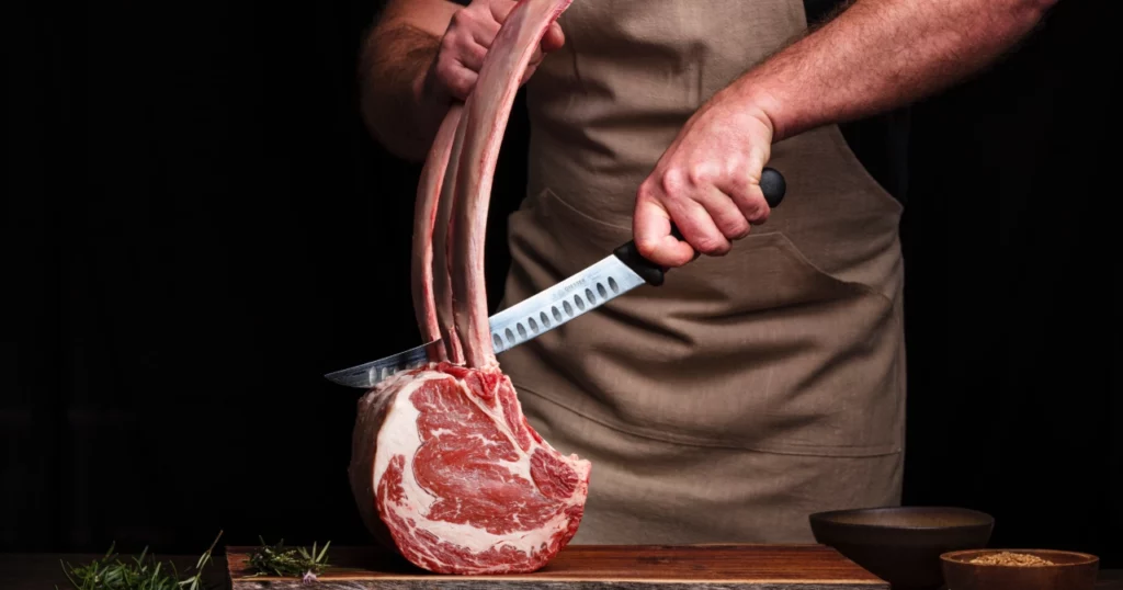 Man carving tomahawk steaks