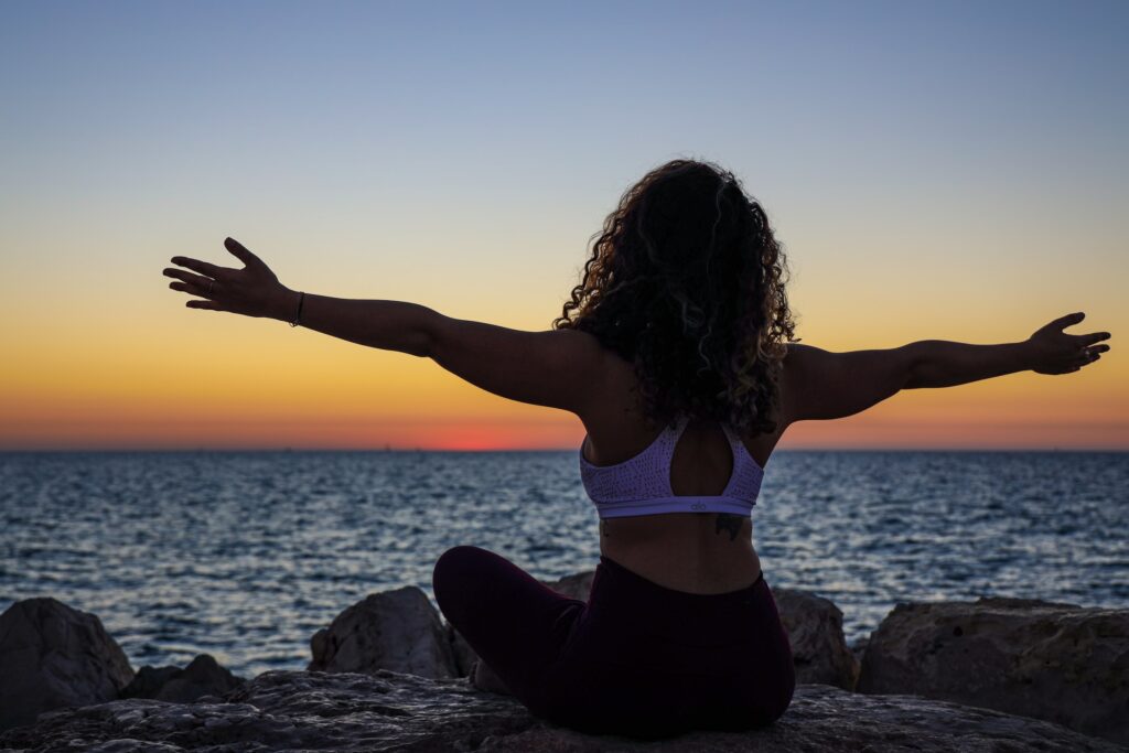 Woman on beach at sunset | Amare - The Mental Wellness Company - Tom Nikkola